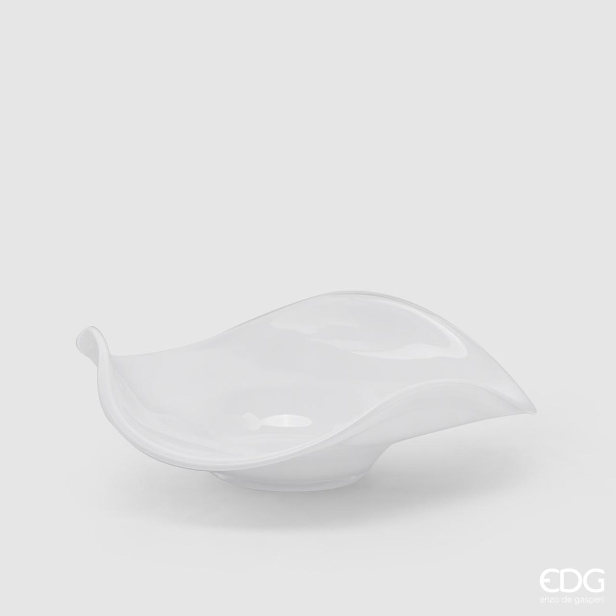 Elegante piatto centrotavola in vetro bianco della collezione Onde di Enzo De Gasperi (EDG) con bordo dal design sinuoso e ondulato, Tutto Chic.