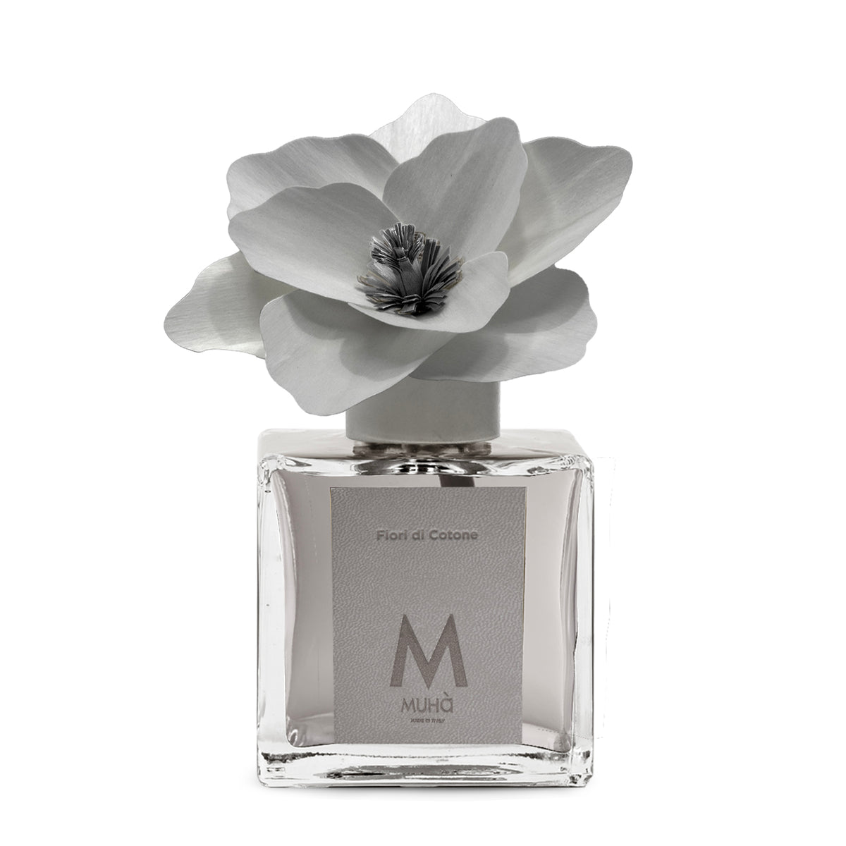 Diffusore d’ambiente con bottiglia in vetro con tappo in zama si accompagna a una magnolia in legno di betulla per diffondere la fragranza Fiori di Cotone. tuttochic.live