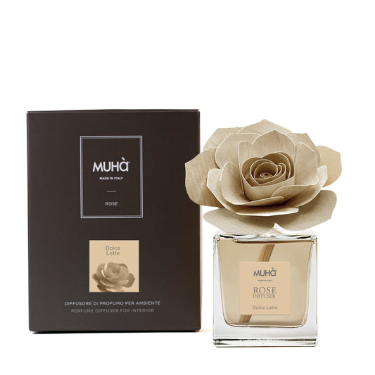 Profumatore d'ambiente Muhà Rose Diffuser Dolce Latte in flacone squadrato di vetro trasparente con essenza color crema, etichetta quadrata centrale e diffusore artigianale a forma di rosa in legno beige chiaro, Tutto Chic.