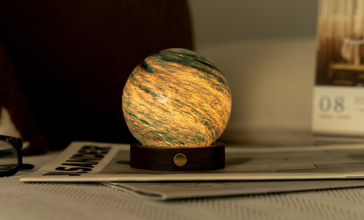 lampada AstraGlass Light. Composta da una sfera in vetro soffiata e dipinta a mano poggiata su una base rotonda in legno di noce americano. Questa lampada è perfetta per chiunque sia affascinato dal meraviglioso fenomeno naturale del nostro mondo. Dimensioni: cm ø 8 x h 9. In negozio e online su tuttochic.live