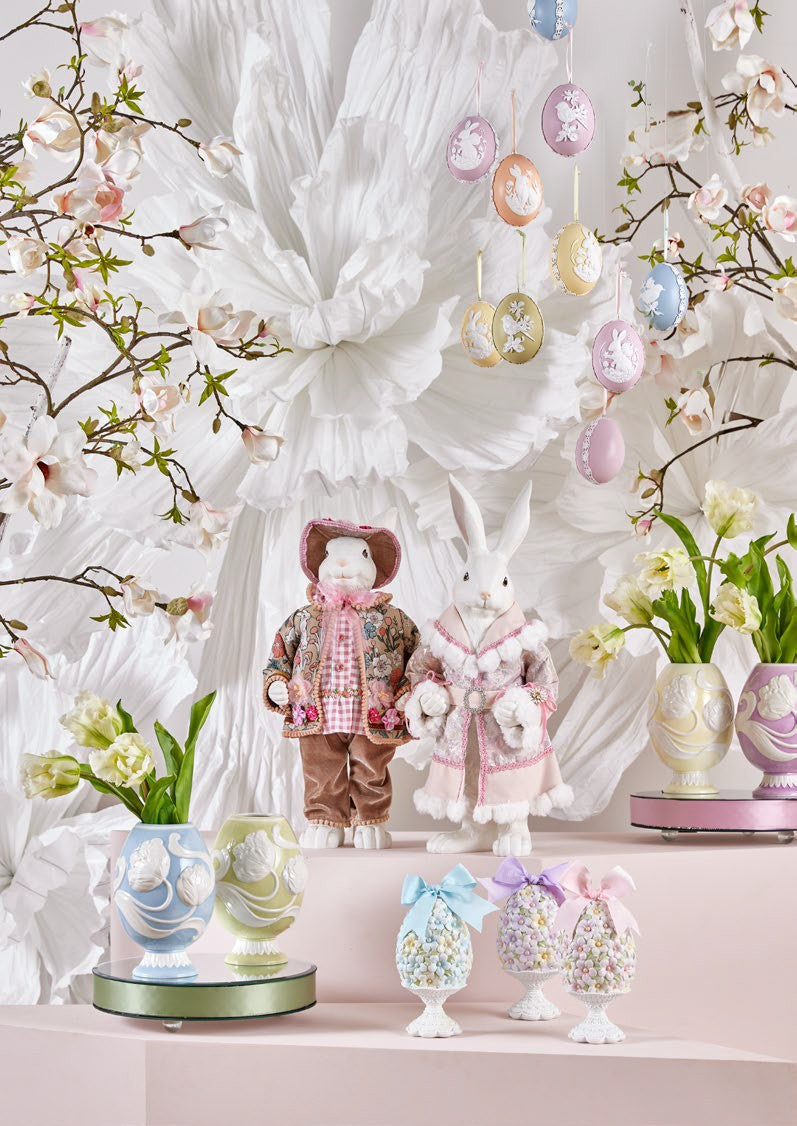 Aggiungi un tocco di eleganza pasquale alla tua casa con il Coniglio Dandy. Realizzato in resina bianca di alta qualità, questo grazioso decoro è abbellito da un vestito in vero tessuto decorato, per un'atmosfera di raffinatezza. Dimensioni: altezza cm 51. In negozio e online su tuttochic.live