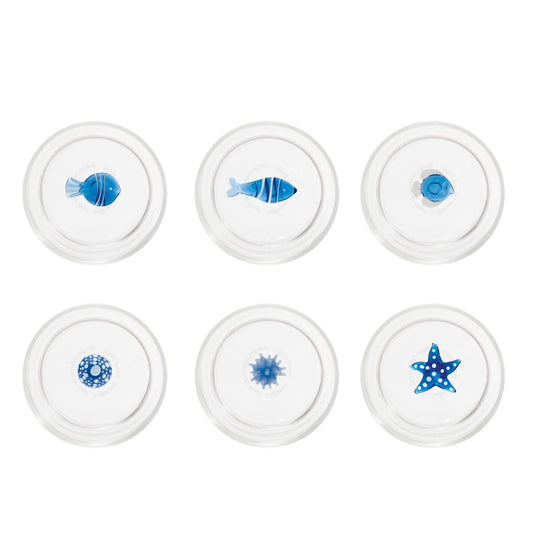 Il set Teca Mare è composto da 6 bicchieri contenenti sei diversi decori a tema “marino”, di colore bianco/blu: la stella di mare, il riccio di mare, il corallo, la sardina, il pesce palla e il pesce bicolore, tutti realizzati a mano. Dimensioni: Ø 8x h 10,5 cm - 35 cl. In negozio e online su tuttochic.live