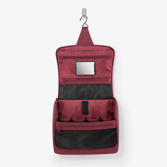 Toiletbag XL Reisenthel aperta e appesa con gancio e prodotti all'interno. Specchio interno con velcro della trousse da viaggio