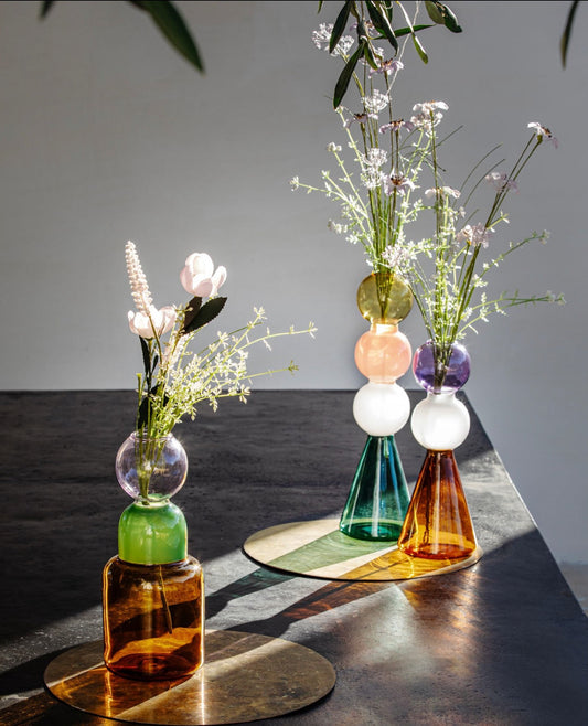 Vaso monofiore in vetro borosilicato. Più che vasi, sembrano piccole sculture in vetro dal design originale e contemporaneo, che regalano a ogni stanza personalità e luce. Alchimia è un omaggio retrò agli alambicchi. Dimensioni: cm Ø 9.5 x 25 h. In negozio e online su tuttochic.live