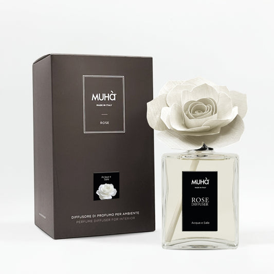 Profumatore d'ambiente Muhà Rose Diffuser Acqua e Sale in flacone grande squadrato di vetro trasparente con essenza limpida, etichetta verticale nera e diffusore artigianale a forma di rosa in legno bianco panna, Tutto Chic.