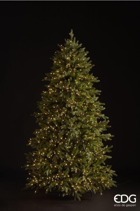 Albero di Natale artificiale Pino Cristallo EDG Enzo De Gasperi H 180 cm con 1500 mini LED a luce calda integrati e telecomando, posizionato in un salotto moderno accanto a una poltrona e un camino.