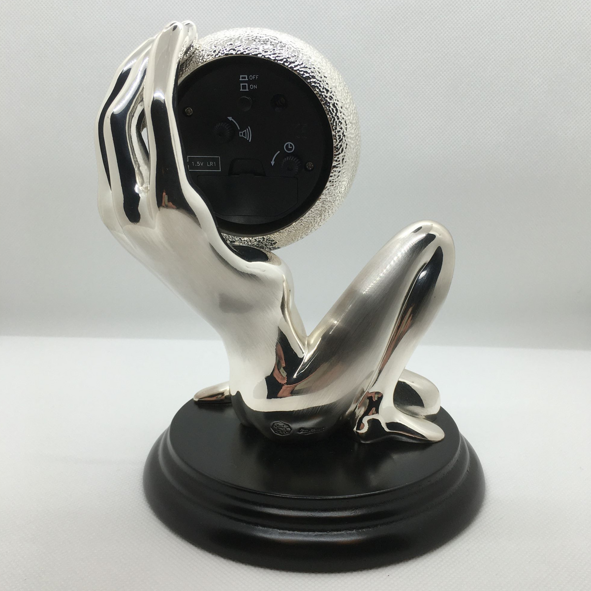 Scultura corpo-mano con orologio e sveglia in bagno galvanico in argento. Dimensioni: cm 15 x 17 h. In negozio e online su tuttochic.live