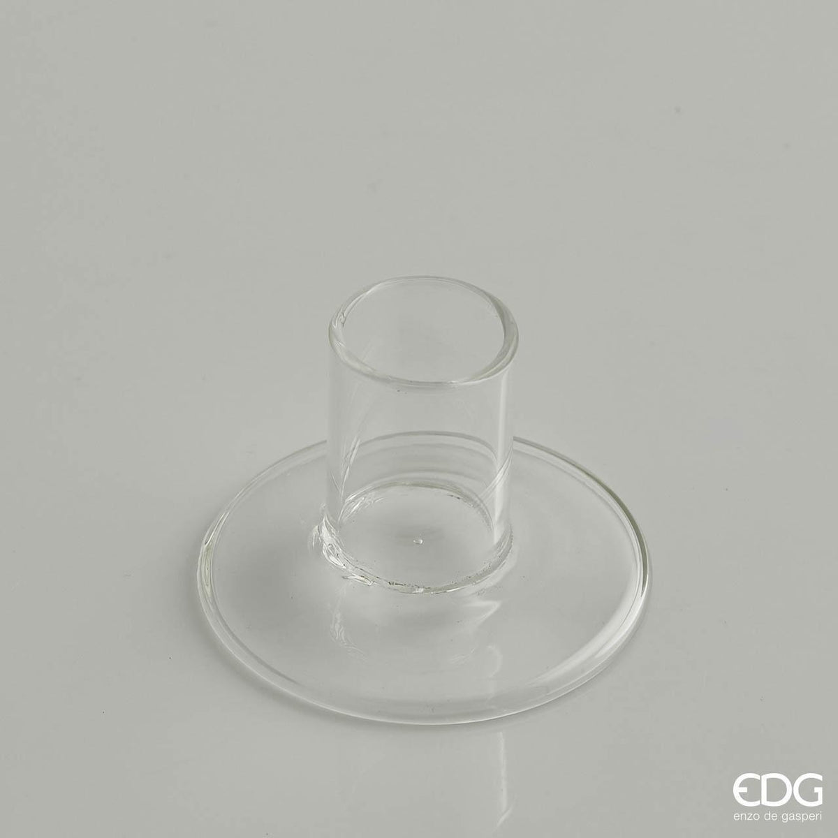 Portacandele base in vetro trasparente. Dimensioni: cm Ø 7 x 5 h, foro Ø 2,5 cm. In negozio e online su tuttochic.live