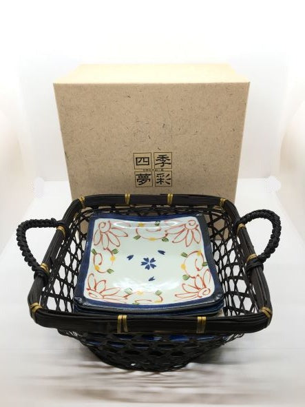 Set di 6 piattini in porcellana giapponese Saiegawari con cestino in vimini di colore nero. Dimensioni: piattino cm 14 x 14 - cestino cm 19, 5 x 25 (con manici) x 11,5 h (con manici). In negozio e online su tuttochic.live