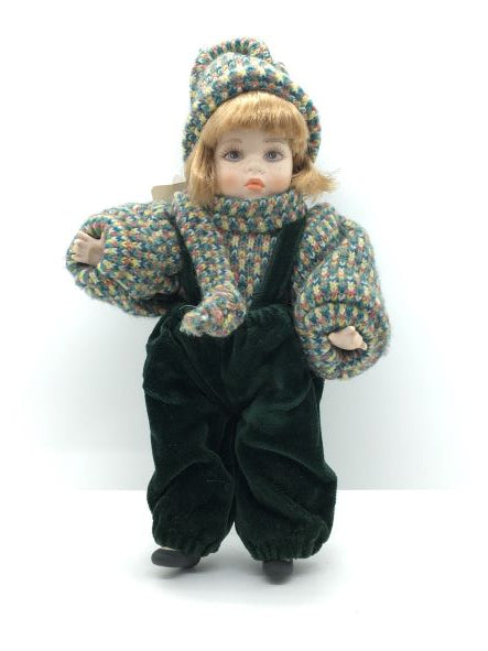 Bambola in porcellana di Capodimonte fatta e dipinta a mano, con mirabile fusione di tecnica e abilità manuale. Corpo, braccia e testa in porcellana snodabile, vestito con velluto verde scuro e cotone multicolorato. Dimensioni: cm 13 x 22 h. In negozio e online su tuttochic.live
