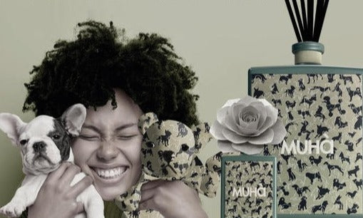 Profumatore per ambiente in una raffinata bottiglia di vetro verniciato con etichetta tessuta in jacquard e diffusore a forma di fiore in legno di betulla naturale realizzato a mano. In negozio e online su tuttochic.live