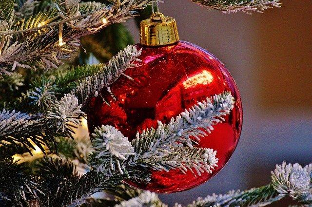 Decorazioni per albero di Natale: palline rosse, oro e bianche, puntali scintillanti e figure natalizie per un albero elegante e raffinato.