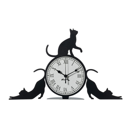 Orologio simpatico Cattitude da tavolo, realizzato in ferro e di colore nero, il complemento d’arredo originale e simpatico da collocare in una scrivania dello studio oppure sul comodino di una camera rappresenta l’allegria e la freschezza degli ambienti. Dimensioni: 48 X 30H cm. In negozio e online su tuttochic.live