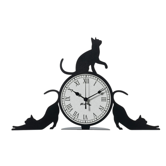 Orologio simpatico Cattitude da tavolo, realizzato in ferro e di colore nero, il complemento d’arredo originale e simpatico da collocare in una scrivania dello studio oppure sul comodino di una camera rappresenta l’allegria e la freschezza degli ambienti. Dimensioni: 48 X 30H cm. In negozio e online su tuttochic.live