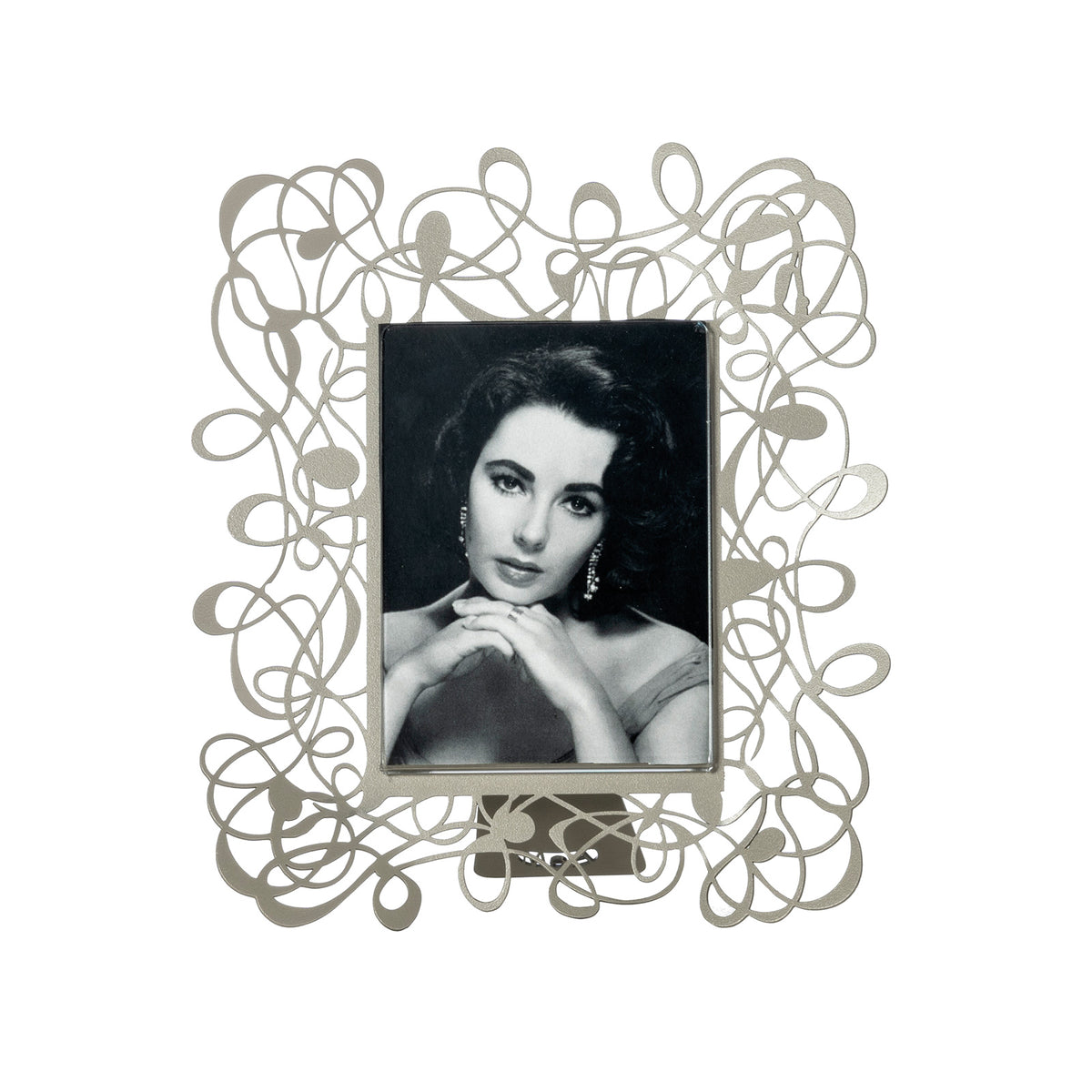 Il porta foto piccolo Scarabocchio è davvero originale  e al tempo stesso elegante e raffinato. Può impreziosire qualsiasi ambiente, salotto, camera da letto oppure studio. Dimensioni 19 x 22 h cm cornice esterna e 10 x 13 h cm foto Materiale: metallo. In negozio e online su tuttochic.live