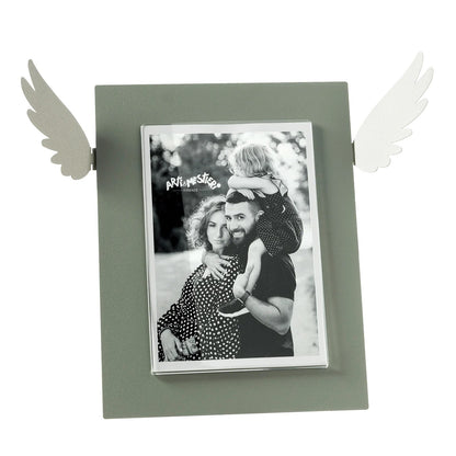 Portafoto Icaro di Arti e Mestieri. Realizzato in metallo colorato con le ali che si estendono dai lati, ispirato al mito di Icaro. Dimensioni: 33,3 x 25 h cm (13x18 formato foto). In negozio e online su tuttochic.live
