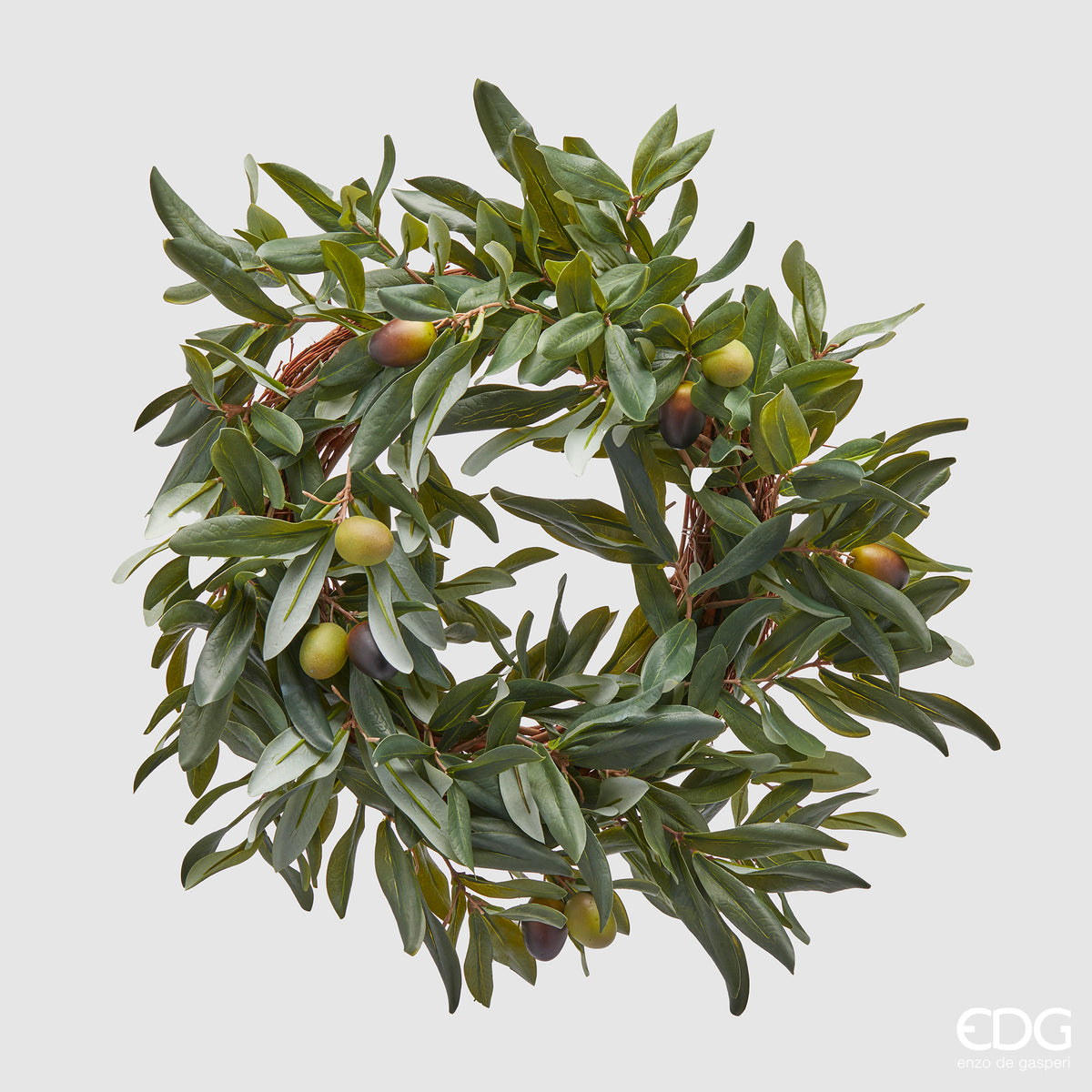 Corona Olivo con olive. Realizzata in plastica verde, questa corona può essere appesa o poggiata, aggiungendo un tocco di classe e originalità alla tua decorazione. Lasciati sedurre dalla bellezza dell'olivo e dalla freschezza della frutta. Dimensioni: diametro cm 40. In negozio e online su tuttochic.live.