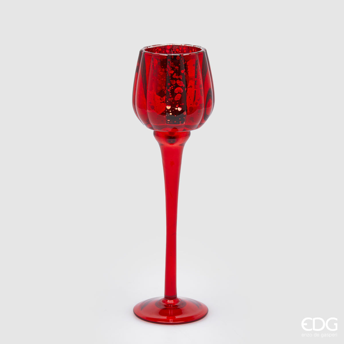 Calice portacandela in vetro lavorato di colore rosso. Dimensioni: cm h 27,5 x ø 8. Per creare un'atmosfera raffinata ed elegante, si consiglia l'acquisto di più pezzi, di colori e misure diverse. In negozio e online su tuttochic.live 