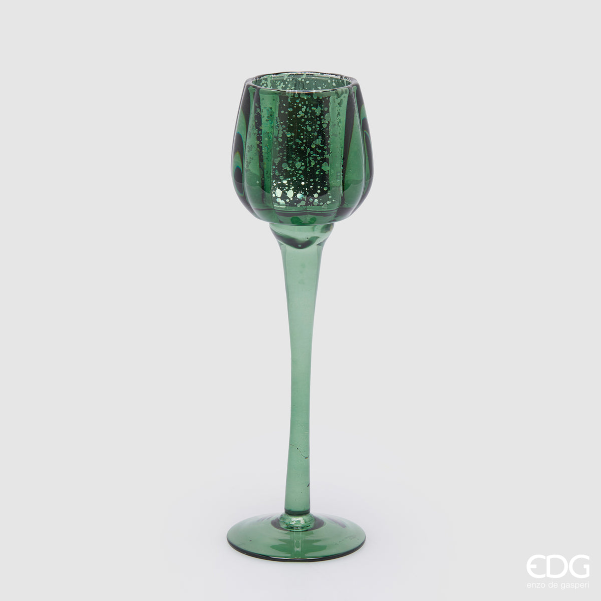 Calice portacandela in vetro lavorato di colore verde. Dimensioni: cm h 27,5 x ø 8. Per creare un'atmosfera raffinata ed elegante, si consiglia l'acquisto di più pezzi, di colori e misure diverse. In negozio e online su tuttochic.live 