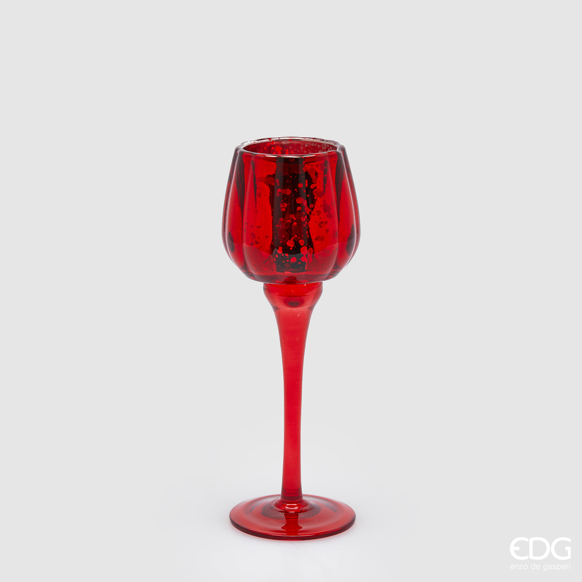Calice portacandela in vetro lavorato di colore rosso. Dimensioni: cm h 22 x ø 8. Per creare un'atmosfera raffinata ed elegante, si consiglia l'acquisto di più pezzi, di colori e misure diverse. In negozio e online su tuttochic.live 