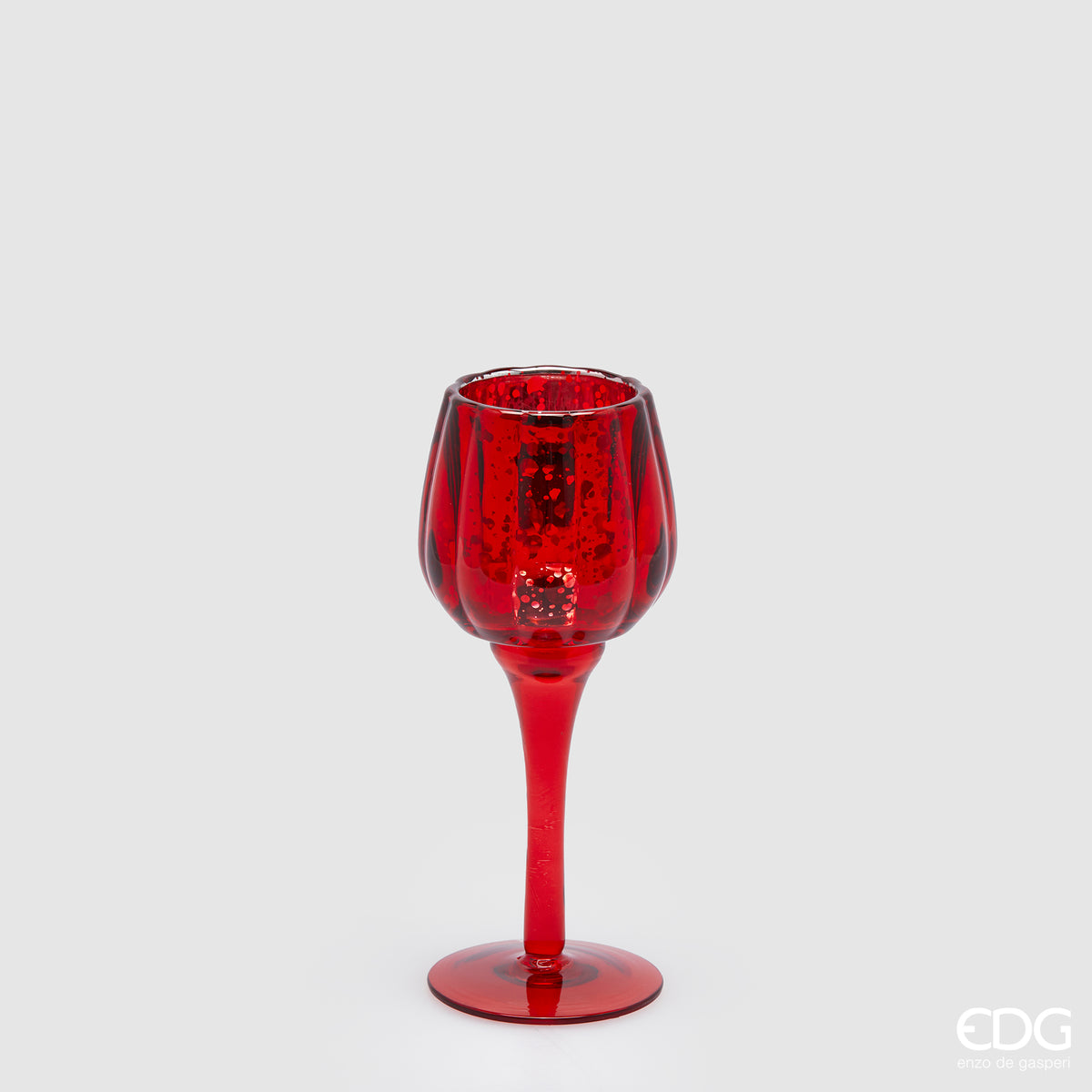 Calice portacandela in vetro lavorato di colore rosso. Dimensioni: cm h 19,5 x ø 8. Per creare un'atmosfera raffinata ed elegante, si consiglia l'acquisto di più pezzi, di colori e misure diverse. In negozio e online su tuttochic.live 