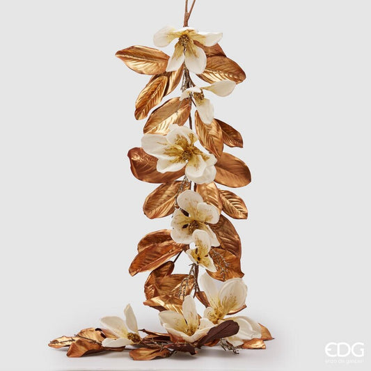 Realizzata in PVC con petali in tessuto bianco, foglie color bronzo e ramo arricchito con paillettes, ideale per abbellire ogni ambiente. Dimensioni: lunga cm 183. In negozio e online su tuttochic.live