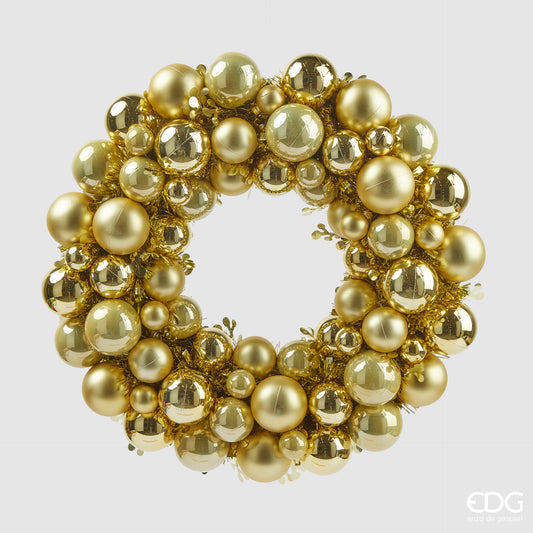 Corona realizzata con palline di diverse misure e ghirlande, in plastica di colore oro. Dimensioni: Ø 39 cm. In negozio e online su tuttochic.live