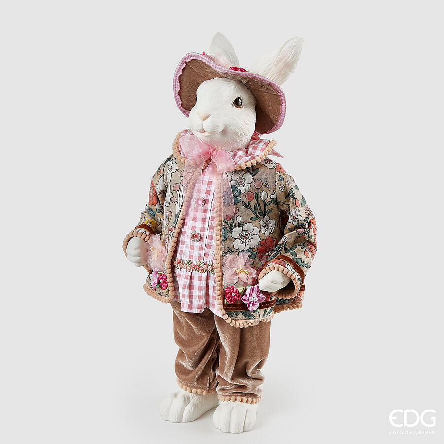 Aggiungi un tocco di eleganza pasquale alla tua casa con il Coniglio Dandy. Realizzato in resina bianca di alta qualità, questo grazioso decoro è abbellito da un vestito in vero tessuto decorato, per un'atmosfera di raffinatezza. Dimensioni: altezza cm 51. In negozio e online su tuttochic.live