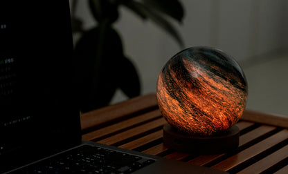 lampada AstraGlass Light. Composta da una sfera in vetro soffiata e dipinta a mano poggiata su una base rotonda in legno di noce americano. Questa lampada è perfetta per chiunque sia affascinato dal meraviglioso fenomeno naturale del nostro mondo. Dimensioni: cm ø 12 x h 13. In negozio e online su tuttochic.live