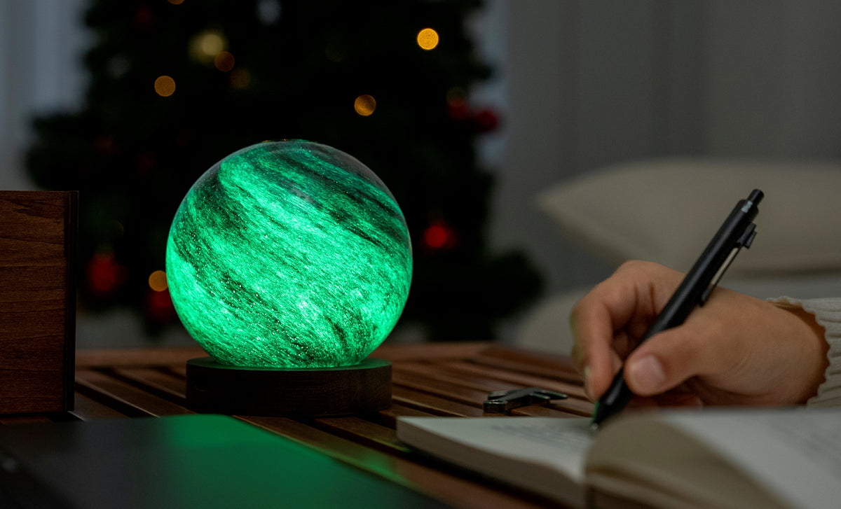 lampada AstraGlass Light. Composta da una sfera in vetro soffiata e dipinta a mano poggiata su una base rotonda in legno di noce americano. Questa lampada è perfetta per chiunque sia affascinato dal meraviglioso fenomeno naturale del nostro mondo. Dimensioni: cm ø 12 x h 13. In negozio e online su tuttochic.live