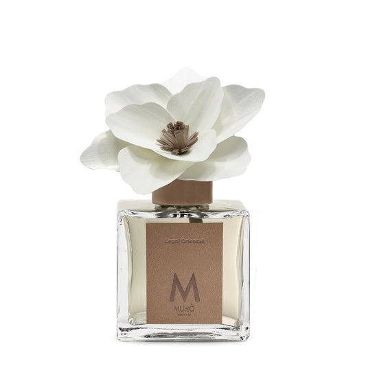 Diffusore d’ambiente con bottiglia in vetro con tappo in zama si accompagna a una magnolia in legno di betulla per diffondere la fragranza Legni Orientali. In negozio e online su tuttochic.live