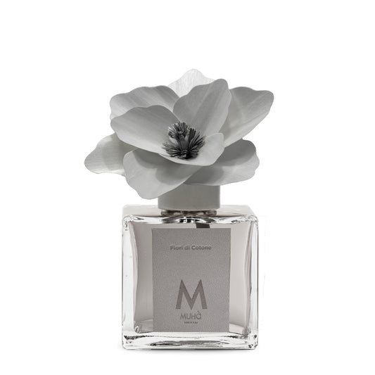 Diffusore d’ambiente con bottiglia in vetro con tappo in zama si accompagna a una magnolia in legno di betulla per diffondere 250 ml di fragranza Fiori di Cotone. tuttochic.live