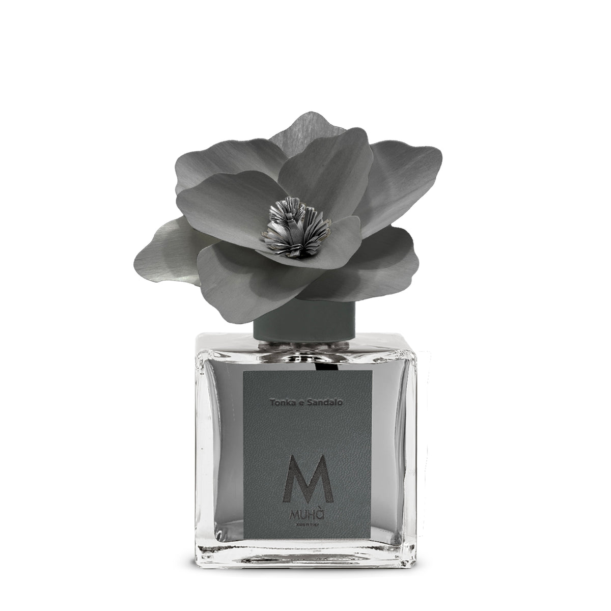 Diffusore d’ambiente con bottiglia in vetro con tappo in zama si accompagna a una magnolia in legno di betulla per diffondere 250 ml di fragranza Tonka e Sandalo. tuttochic.live
