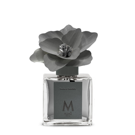 Diffusore d’ambiente con bottiglia in vetro con tappo in zama si accompagna a una magnolia in legno di betulla per diffondere 250 ml di fragranza Tonka e Sandalo. tuttochic.live