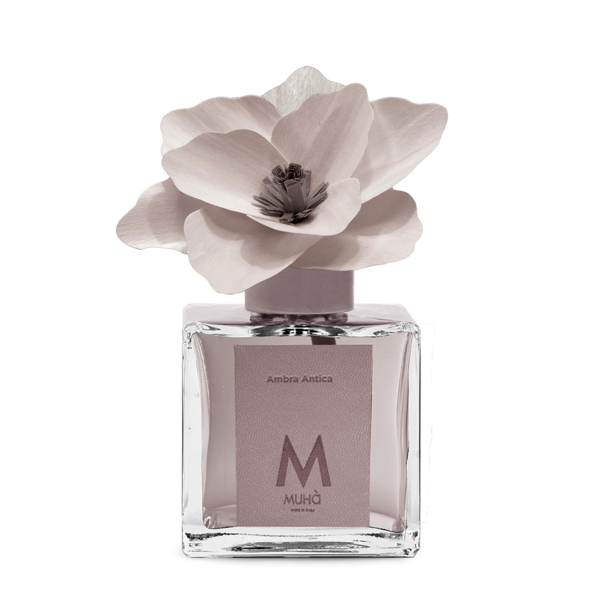 Diffusore d’ambiente con bottiglia in vetro con tappo in zama si accompagna a una magnolia in legno di betulla per diffondere la fragranza Ambra Antica. tuttochic.live