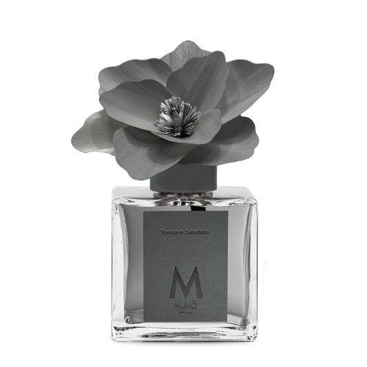 Diffusore d’ambiente con bottiglia in vetro con tappo in zama si accompagna a una magnolia in legno di betulla per diffondere la fragranza Tonka e Sandalo. tuttochic.live