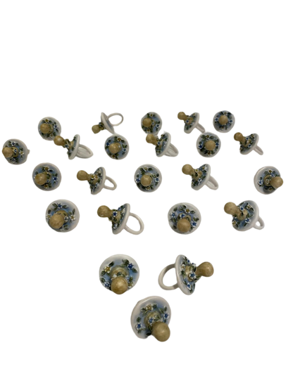 Set di 23 ciucciotti in porcellana stile capodimonte con sfumature di colore celeste. Dimensioni: cm 4,5 x 7 Confettata e astuccio non inclusi. tuttochic.live