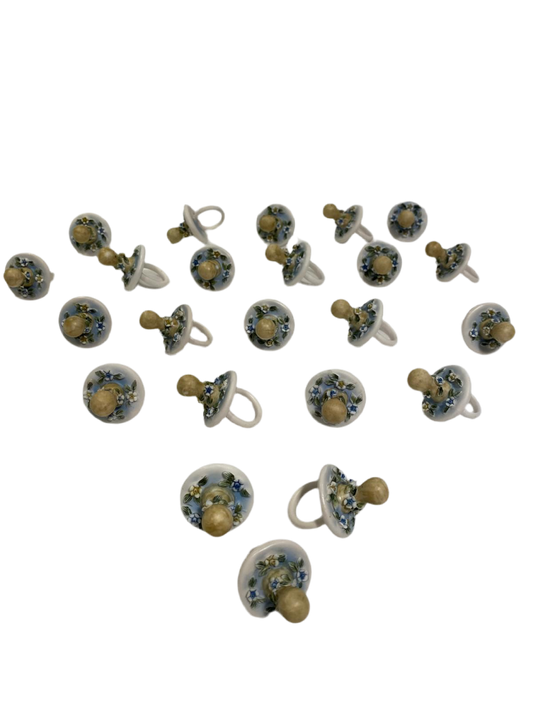 Set di 23 ciucciotti in porcellana stile capodimonte con sfumature di colore celeste. Dimensioni: cm 4,5 x 7 Confettata e astuccio non inclusi. tuttochic.live