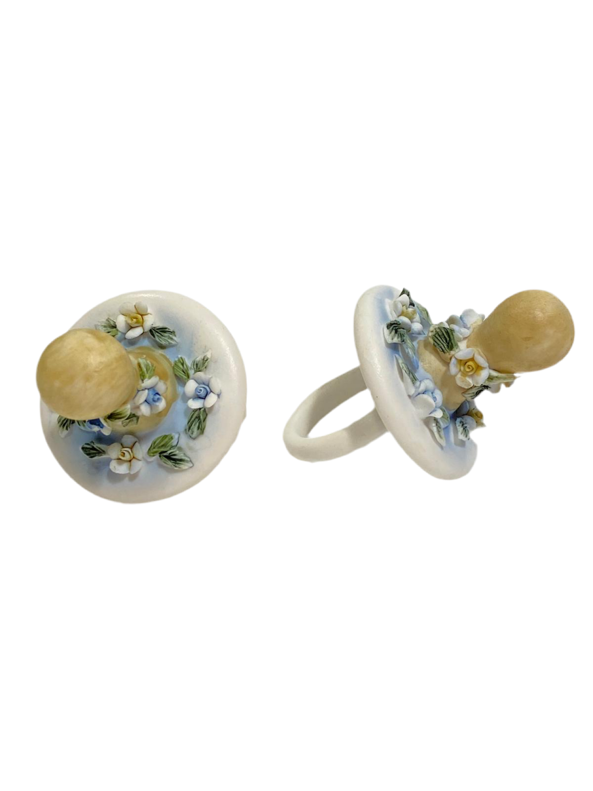 Set di 23 ciucciotti in porcellana stile capodimonte con sfumature di colore celeste. Dimensioni: cm 4,5 x 7 Confettata e astuccio non inclusi. tuttochic.live
