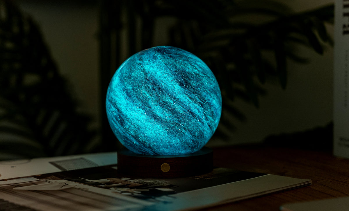 lampada AstraGlass Light. Composta da una sfera in vetro soffiata e dipinta a mano poggiata su una base rotonda in legno di noce americano. Questa lampada è perfetta per chiunque sia affascinato dal meraviglioso fenomeno naturale del nostro mondo. Dimensioni: cm ø 12 x h 13. In negozio e online su tuttochic.live