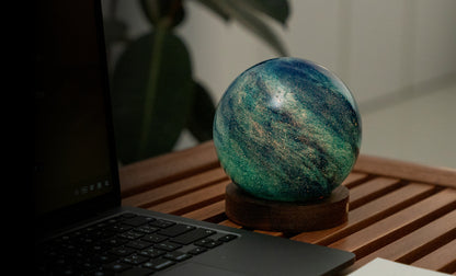 lampada AstraGlass Light. Composta da una sfera in vetro soffiata e dipinta a mano poggiata su una base rotonda in legno di noce americano. Questa lampada è perfetta per chiunque sia affascinato dal meraviglioso fenomeno naturale del nostro mondo. Dimensioni: cm ø 12 x h 13. In negozio e online su tuttochic.live