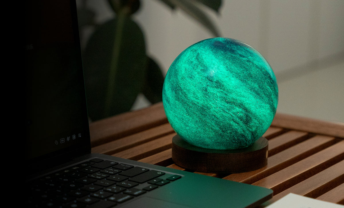 lampada AstraGlass Light. Composta da una sfera in vetro soffiata e dipinta a mano poggiata su una base rotonda in legno di noce americano. Questa lampada è perfetta per chiunque sia affascinato dal meraviglioso fenomeno naturale del nostro mondo. Dimensioni: cm ø 12 x h 13. In negozio e online su tuttochic.live
