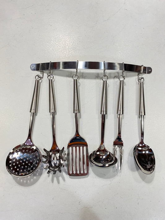 Set di 7 pezzi in acciaio inox composto da 1 Cucchiaione, 1 Forchettone, 1 Mestolo, 1 Paletta, 1 Servispaghetti, 1 Schiumarola e 1 Appendimestoli da parete (corredato di 2 tasselli). Dimensioni: cm 43 x 39 h. In negozio e online su tuttochic.live