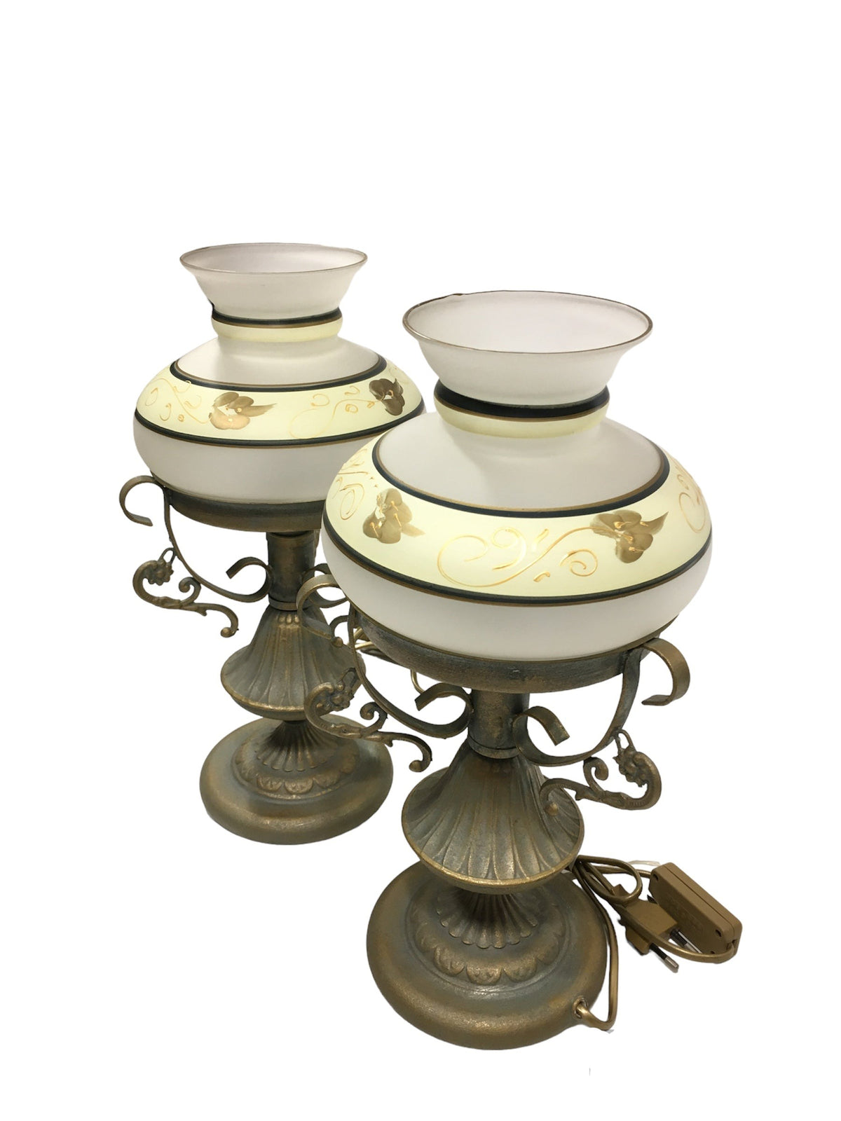 Set di 2 lampade in stile classico in metallo di colore oro e verde (effetto verderame), coppe in vetro sabbiato decorate a mano. Corredate di cavo con interruttore, funzionano con una lampadina attacco piccolo E14 (non incluse). Dimensioni: cm 18 x 37 h - base cm 14. In negozio e online su tuttochic.live