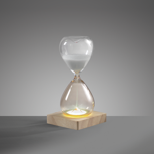 Clessidra in vetro bicolore ambra/trasparente con base in legno illuminata a led. Durata di 30 minuti circa, corredata di cavetto di alimentazione USB. Dimensioni: cm 10 x 10 x 20 h.In negozio e online su tuttochic.live