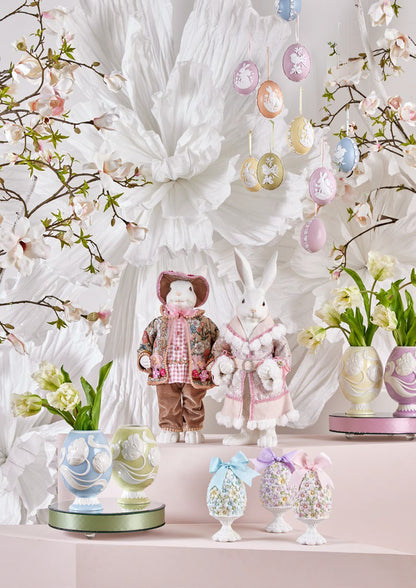 Aggiungi un tocco di eleganza pasquale alla tua casa con il Coniglio Dandy. Realizzato in resina bianca di alta qualità, questo grazioso decoro è abbellito da un vestito in vero tessuto decorato, per un'atmosfera di raffinatezza. Dimensioni: altezza cm 51. In negozio e online su tuttochic.live