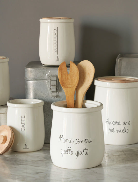 Biscottiera tonda in porcellana bianca decorata con coperchio ermetico in legno chiaro. Dimensioni: cm Ø 16 x h 19 - capacità 2,5 litri. In negozio e online su tuttochic.live