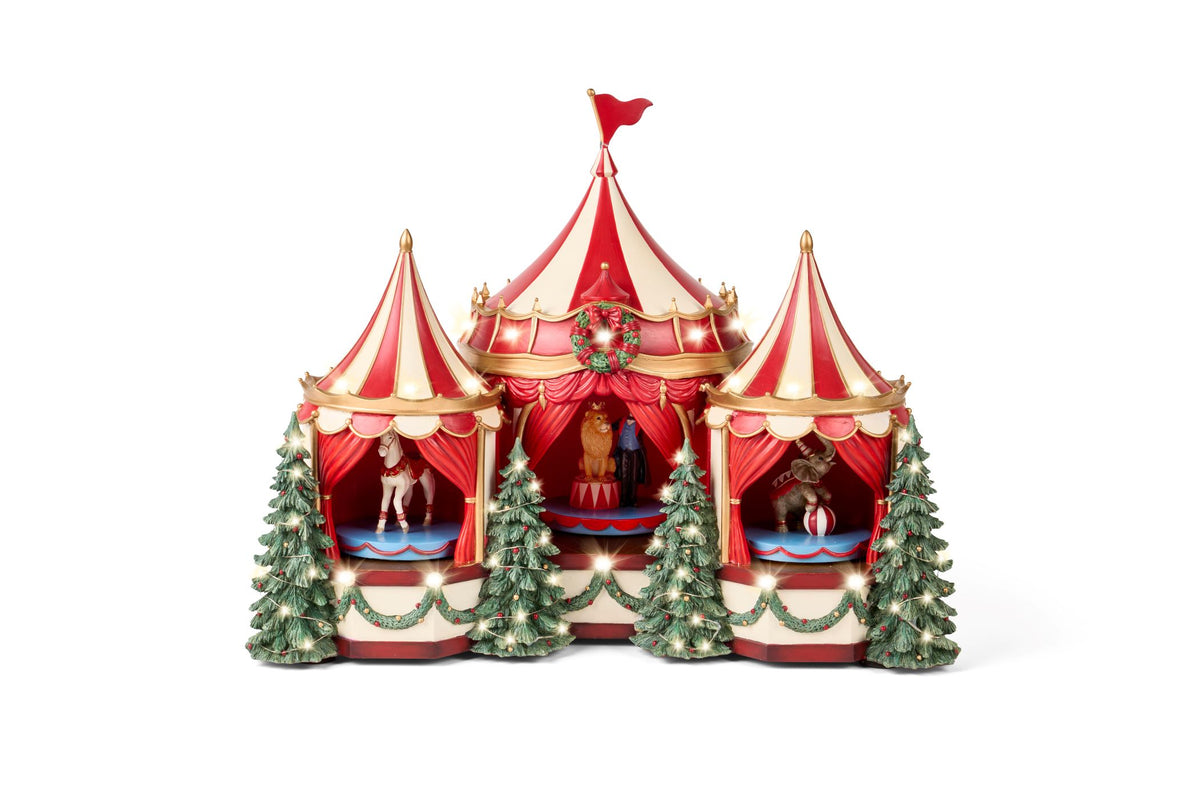 Grande carillon natalizio a forma di circo vintage a tre cupole rosse e panna in resina, con personaggi animati di leone, cavallo ed elefante, decorato con alberi di pino e illuminato da tantissime luci LED calde, collezione Velvet Luxury Nuvole di Stoffa, Tutto Chic.