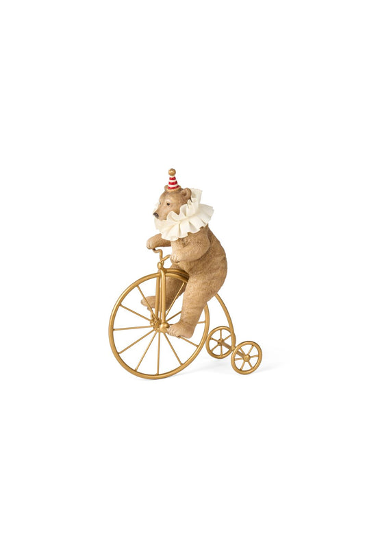 Statuina natalizia decorativa in resina a forma di orsetto marrone chiaro da circo con colletto bianco, mentre pedala su un antico biciclo vintage color oro lucido, altezza 25,5 cm, collezione Velvet Luxury Nuvole di Stoffa, Tutto Chic.