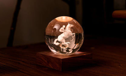 La lampada composta da una sfera in cristallo con decoro interno inciso al laser in 3D su una base quadrata in legno massello di noce naturale. Dimensioni: cm 8 x 8 x h 9,. In negozio e online su tuttochic.live